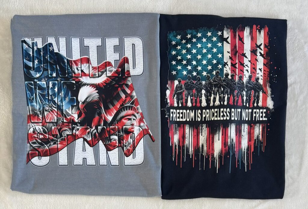 Two folded patriotic t-shirts: United We Stand and Freedom is Priceless
