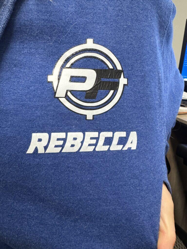 Royal blue hoodie with a PF crosshair logo and the name Rebecca